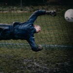 goleiro pulando em direção à bola